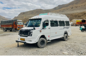 A white bus parked in front of a majestic mountain, symbolizing adventure and exploration in tour and travel.